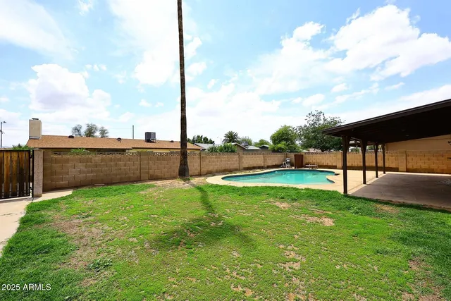 a view of a backyard with swimming pool