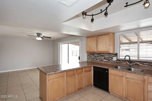 a kitchen with a sink dishwasher a stove and white cabinets with wooden floor