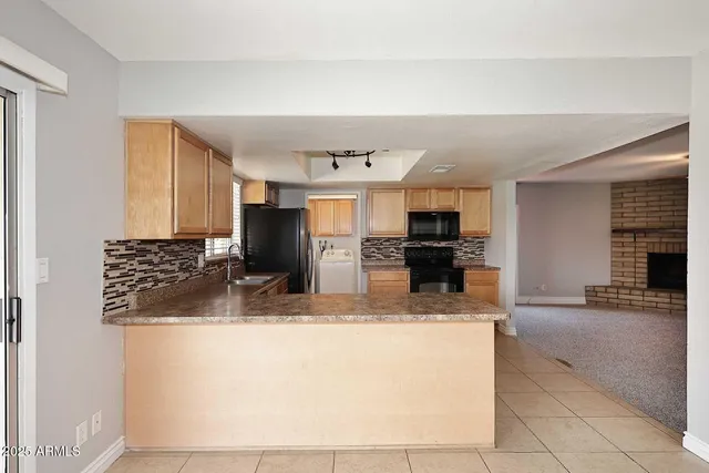 a kitchen with stainless steel appliances granite countertop a sink and a refrigerator