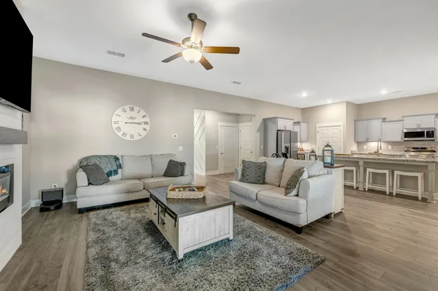 a living room with furniture kitchen view and a flat screen tv