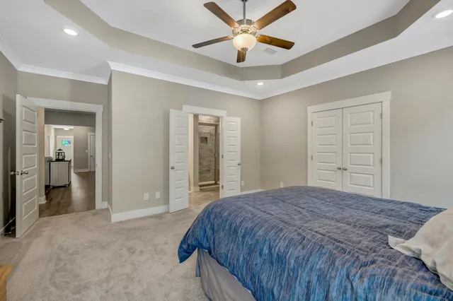 a bedroom with a large bed and a chandelier