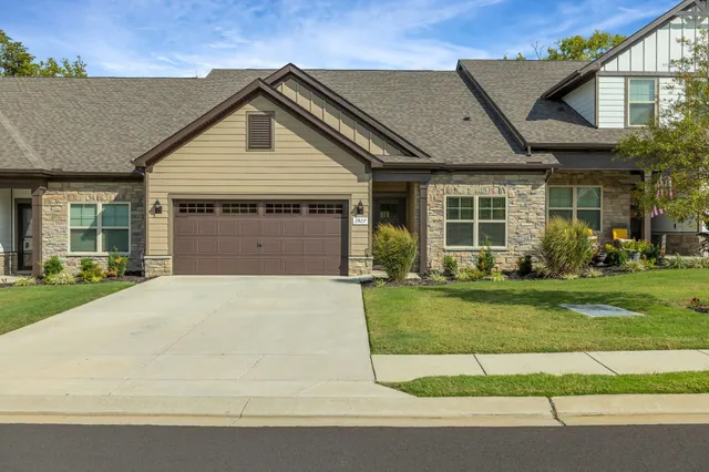 a front view of a house with a garden and plants