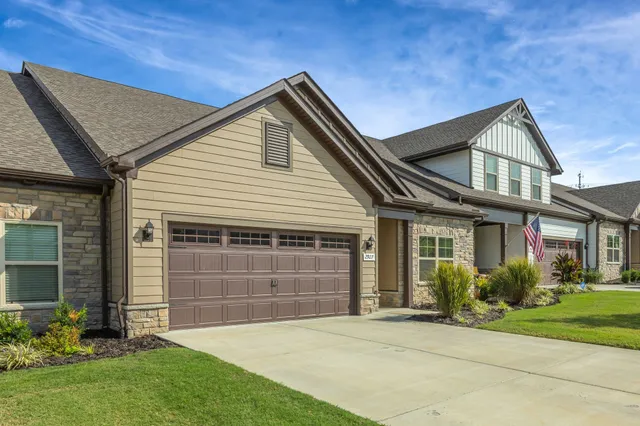 a front view of a house with a garden and plants