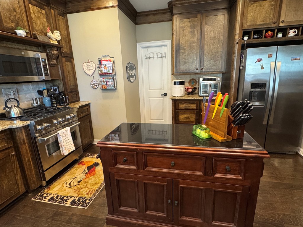 200 Harbor Run Drive Coldspring, TX 77331 - Photo 14 of 50 a kitchen with stainless steel appliances granite countertop a stove refrigerator and microwave