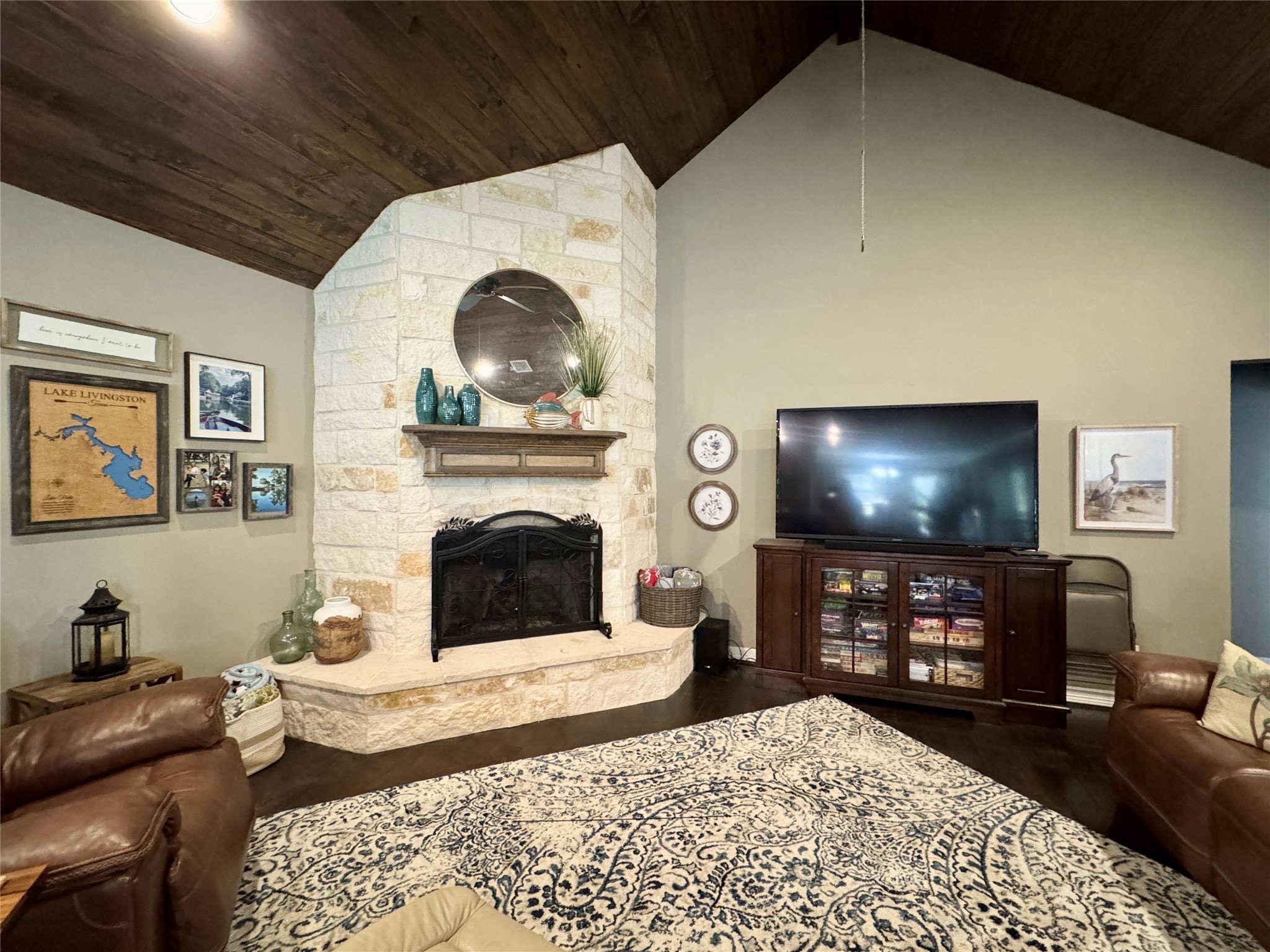 200 Harbor Run Drive Coldspring, TX 77331 - Photo 19 of 50 This spacious living room features a high, wood ceiling and a rustic stone fireplace with a wooden mantel. It has comfortable seating space, lots of windows, engineered wood floor and is open to the kitchen and breakfast bar.