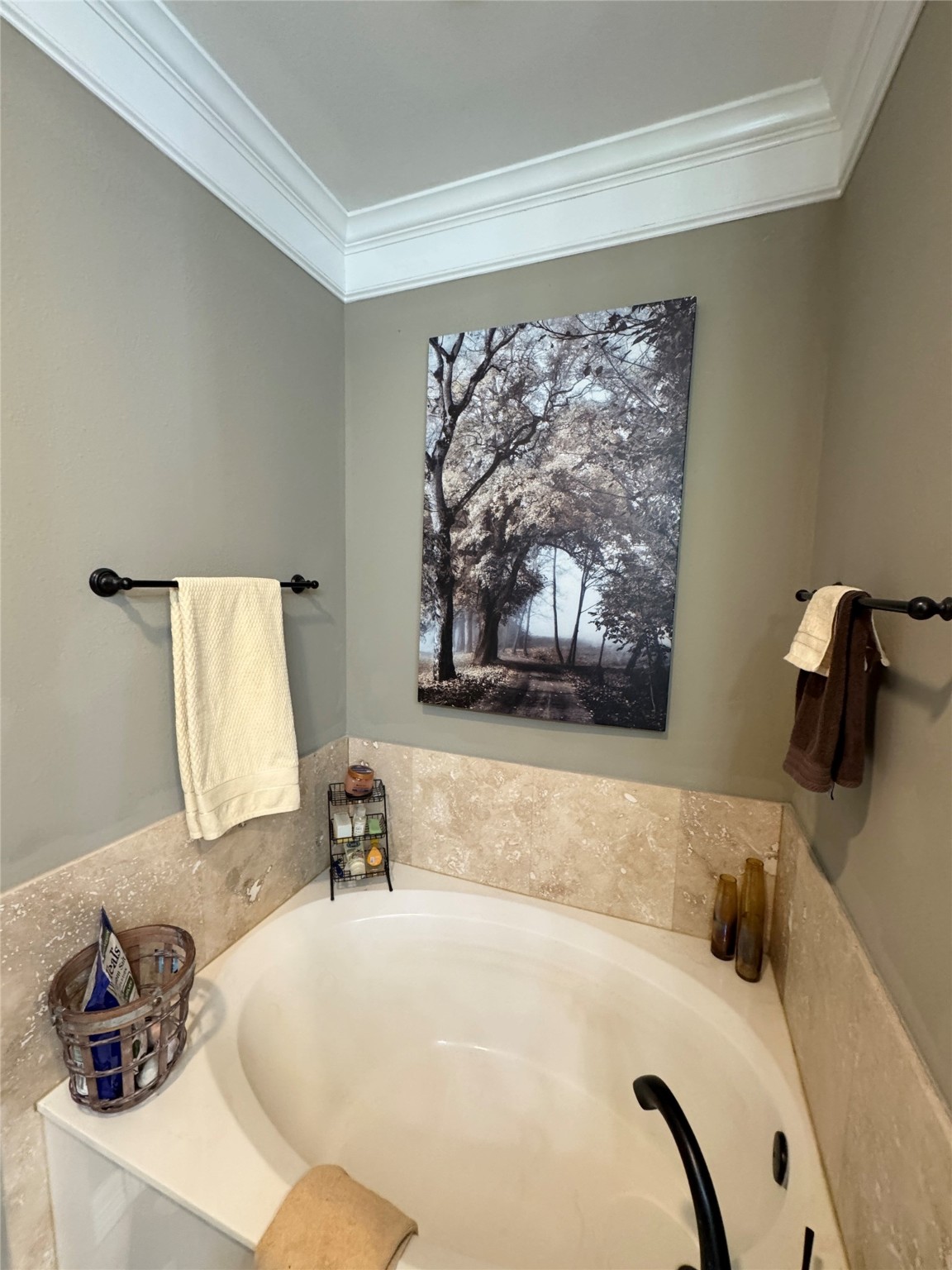 200 Harbor Run Drive Coldspring, TX 77331 - Photo 27 of 50 This bathroom features a lovely soaker bathtub with beige tile surround. It includes towel racks, and bronze fixtures. Just another part of the relaxing atmosphere of this home.