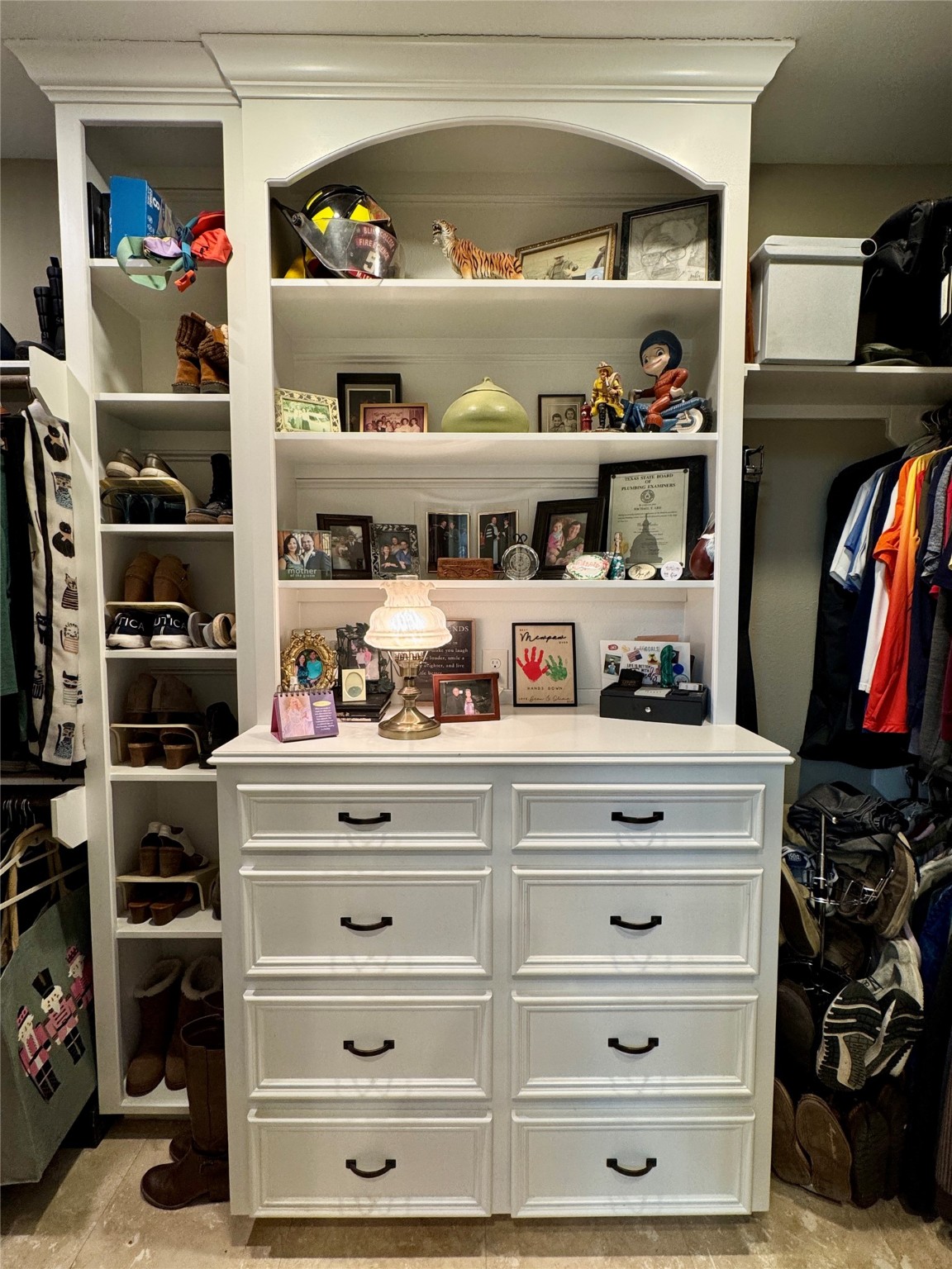 200 Harbor Run Drive Coldspring, TX 77331 - Photo 30 of 50 This photo shows a well-organized closet with built-in white cabinetry. It features multiple drawers and open shelves for generous storage. This built-in cabinetry separates the two areas of the closet, giving each individual their own space -- or it could even be used to separate winter from summer clothing. In either case, it's AMAZING!