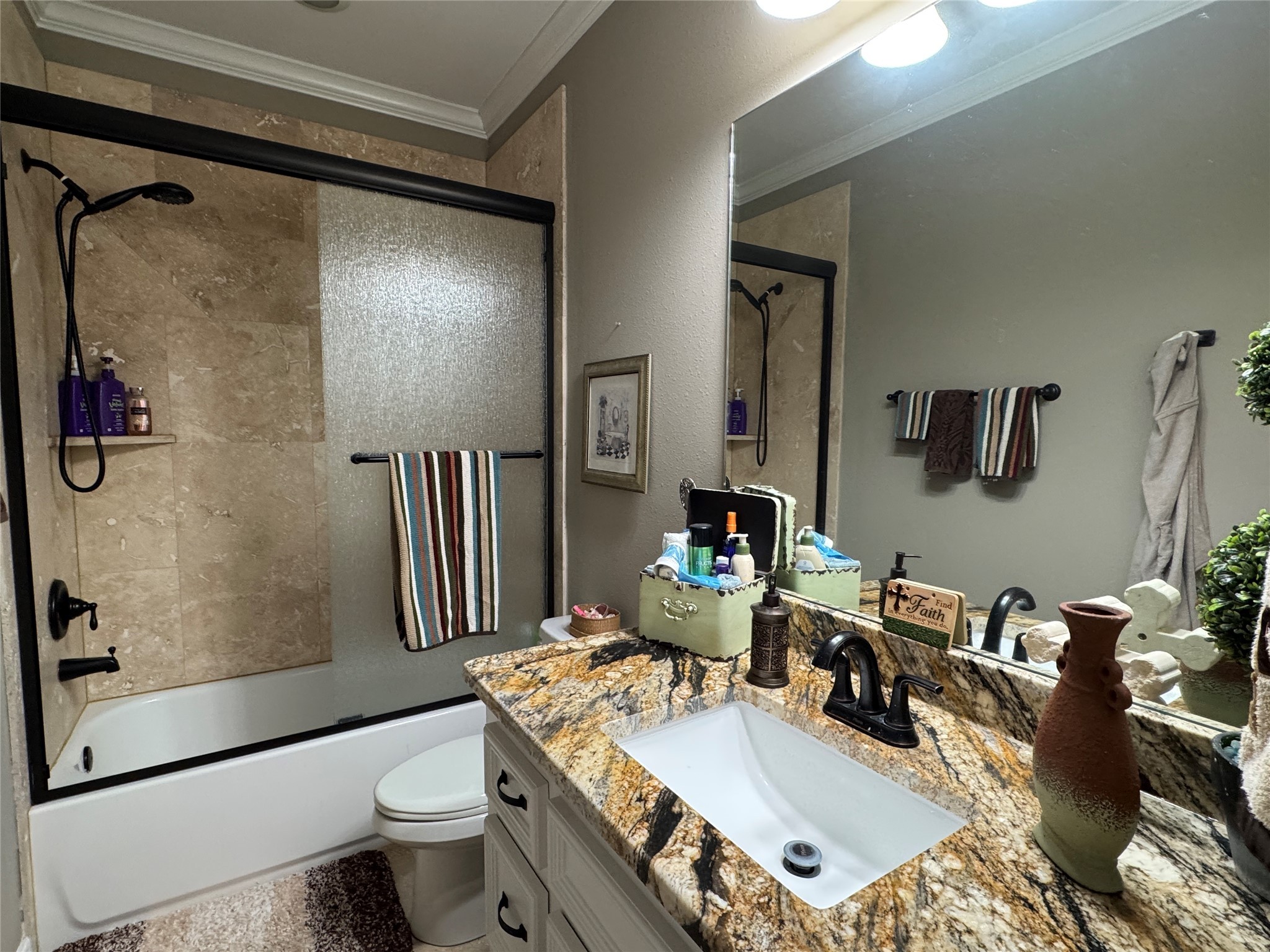 200 Harbor Run Drive Coldspring, TX 77331 - Photo 33 of 50 This bathroom features a modern design with a granite countertop, tile floor, under-mount sink, and dark fixtures. There's a shower/tub combo with a sliding glass door and tiled walls. Tons of storage is offered in the vanity and built in linen closet. See next photo,