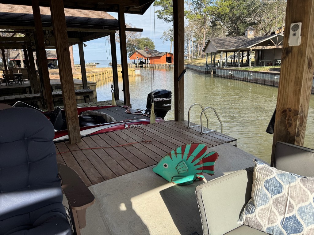 200 Harbor Run Drive Coldspring, TX 77331 - Photo 40 of 50 This waterfront gathering place has a dock area with a covered boat slip, seating, and charming views of a peaceful inlet. Perfect for boating enthusiasts and relaxation by the water.