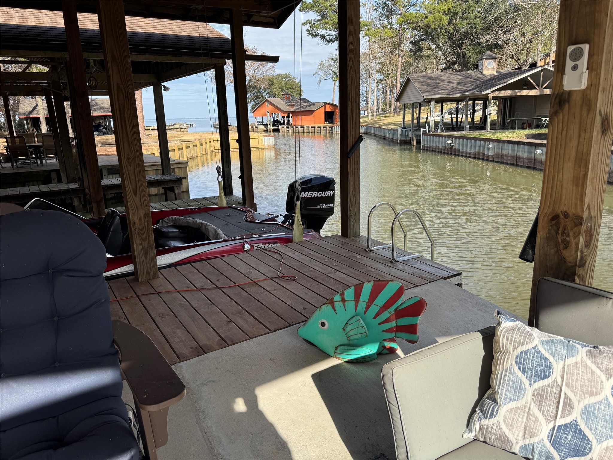 200 Harbor Run Drive Coldspring, TX 77331 - Photo 41 of 50 This waterfront gathering place has a dock area with a covered boat slip, seating, and charming views of a peaceful inlet. Perfect for boating enthusiasts and relaxation by the water.