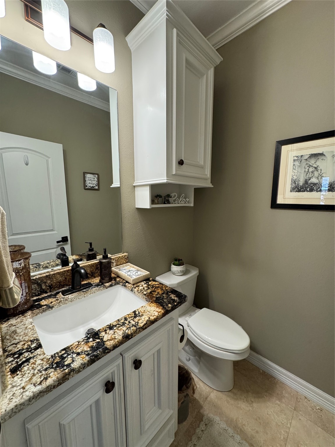200 Harbor Run Drive Coldspring, TX 77331 - Photo 6 of 50 This is a lovely half bath that features a granite countertop with a stylish white vanity, a modern sink, and elegant lighting. It has a framed mirror, neutral wall color, and a cabinet for extra storage. The space is well-lit and inviting.