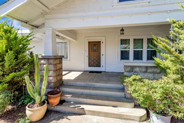 a front view of a house with potted plants