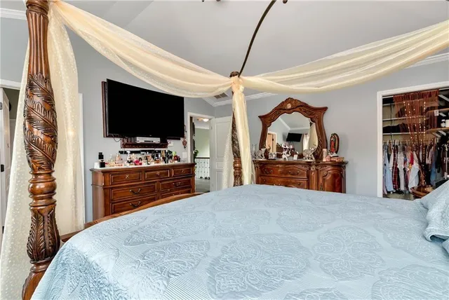 a view of walk in closet with clothes and shoes