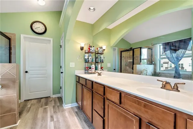 a utility room with a washing machine and a wooden floor