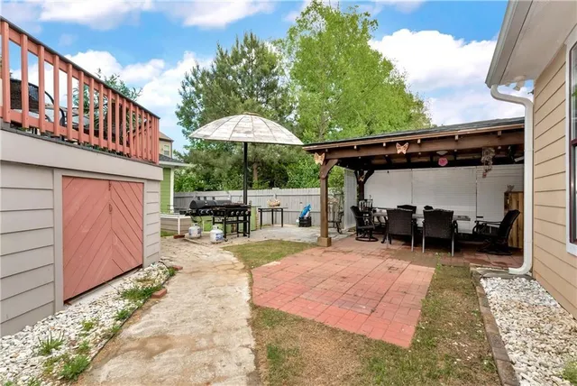 a view of a patio with table and chairs under an umbrella