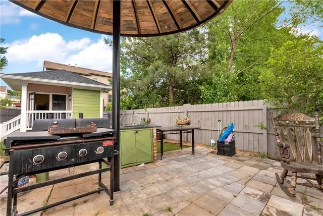 a view of a patio with couches chairs and floor to ceiling window with wooden floor