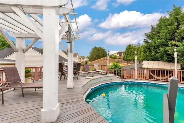 a view of a house with a small yard and wooden fence