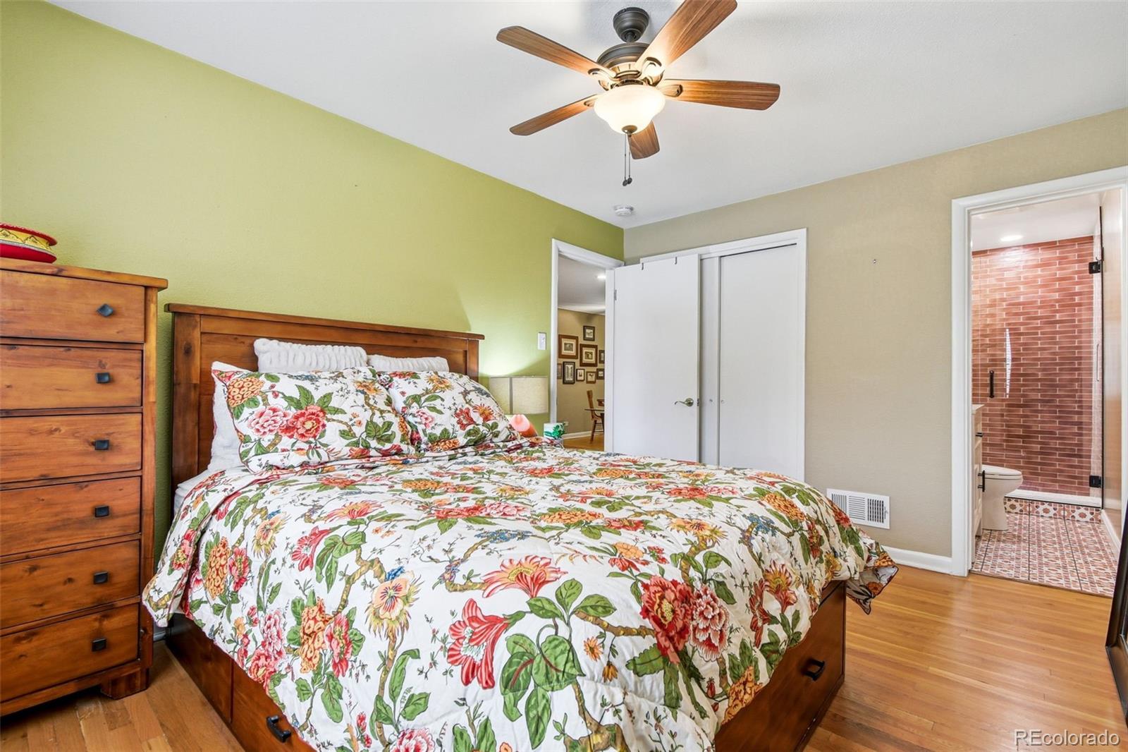 221 Oneida Street Denver, CO 80220 - Photo 11 of 24 a bedroom with a large bed and a chandelier