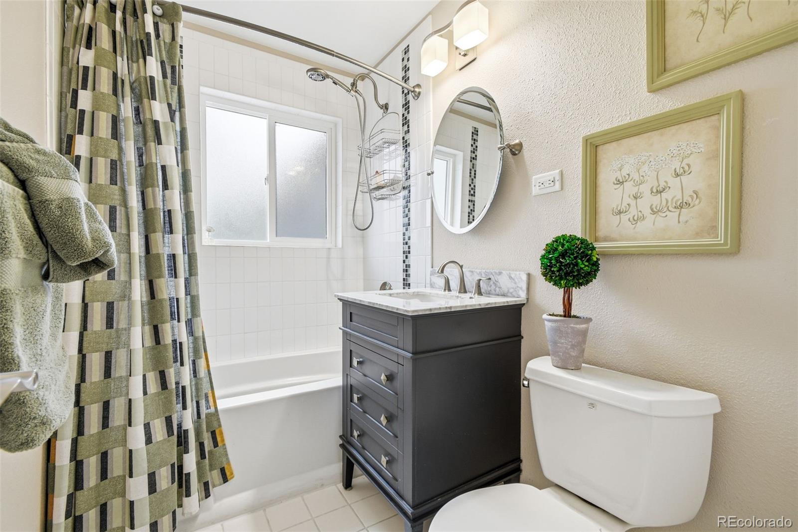 221 Oneida Street Denver, CO 80220 - Photo 14 of 24 a bathroom with a toilet a sink and a mirror
