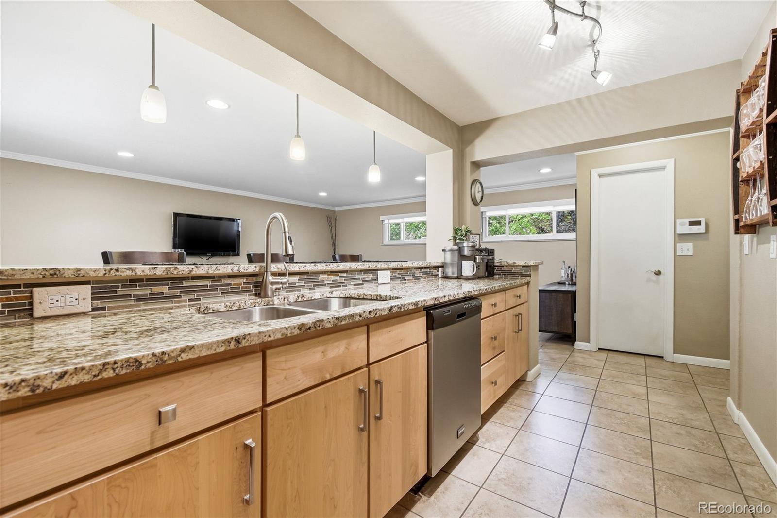 221 Oneida Street Denver, CO 80220 - Photo 7 of 24 a kitchen with stainless steel appliances kitchen island granite countertop a sink and cabinets