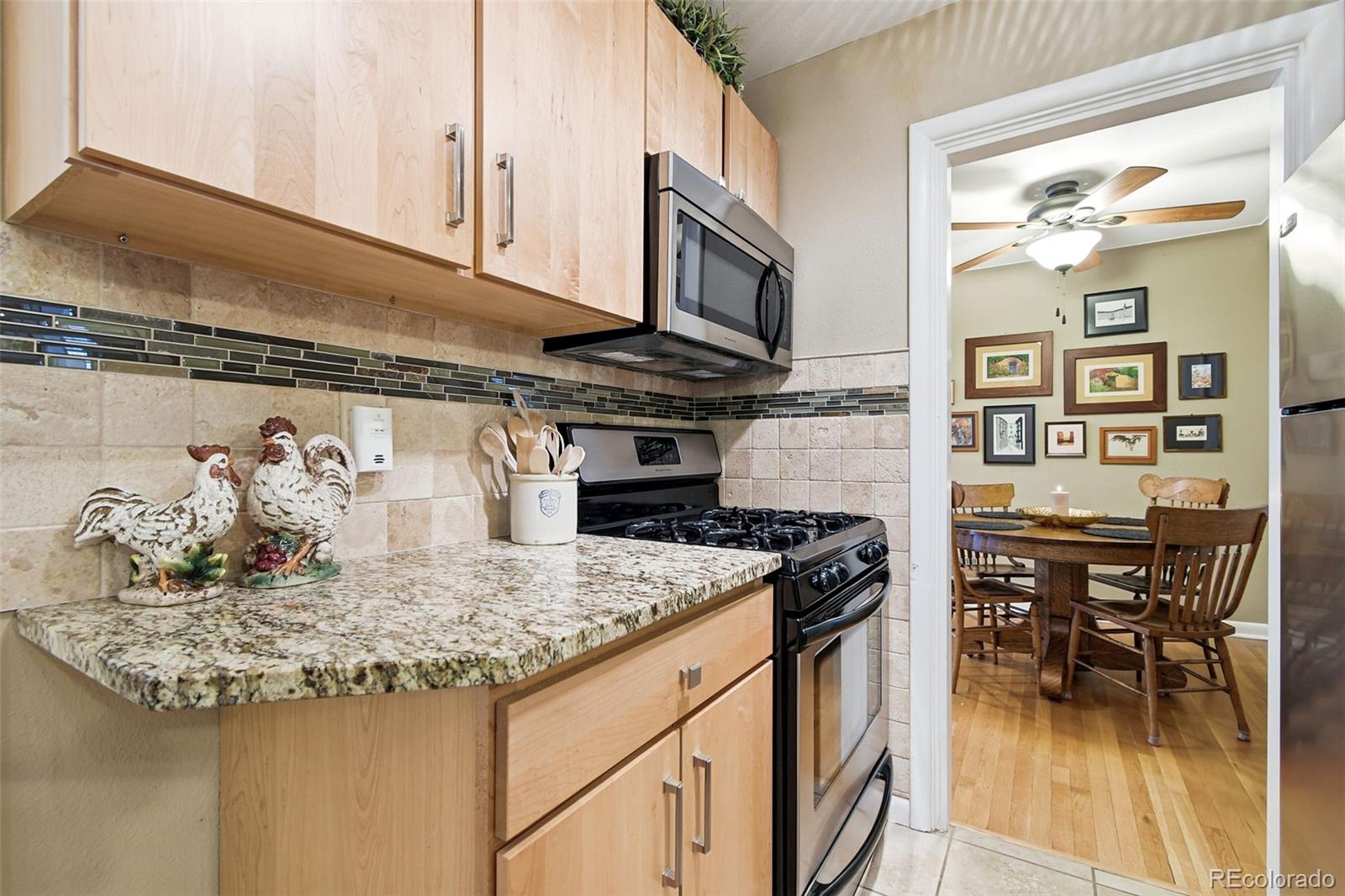 221 Oneida Street Denver, CO 80220 - Photo 8 of 24 a kitchen with stainless steel appliances granite countertop a stove and cabinets