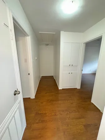 a view of empty room with wooden floor