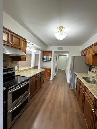 a kitchen with stainless steel appliances granite countertop a stove and a refrigerator