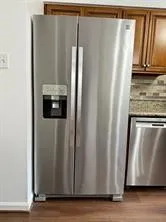a view of a kitchen with refrigerator and wooden floor