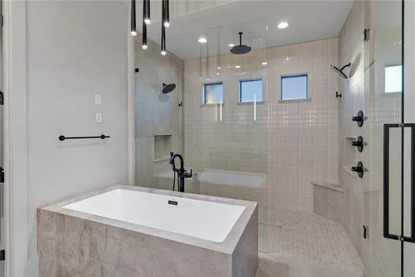 a bathroom with a bathtub a shower a sink and vanity