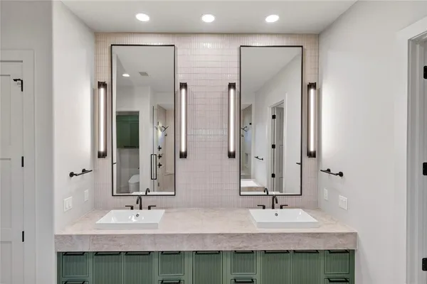 a bathroom with double vanity sinks and a mirror