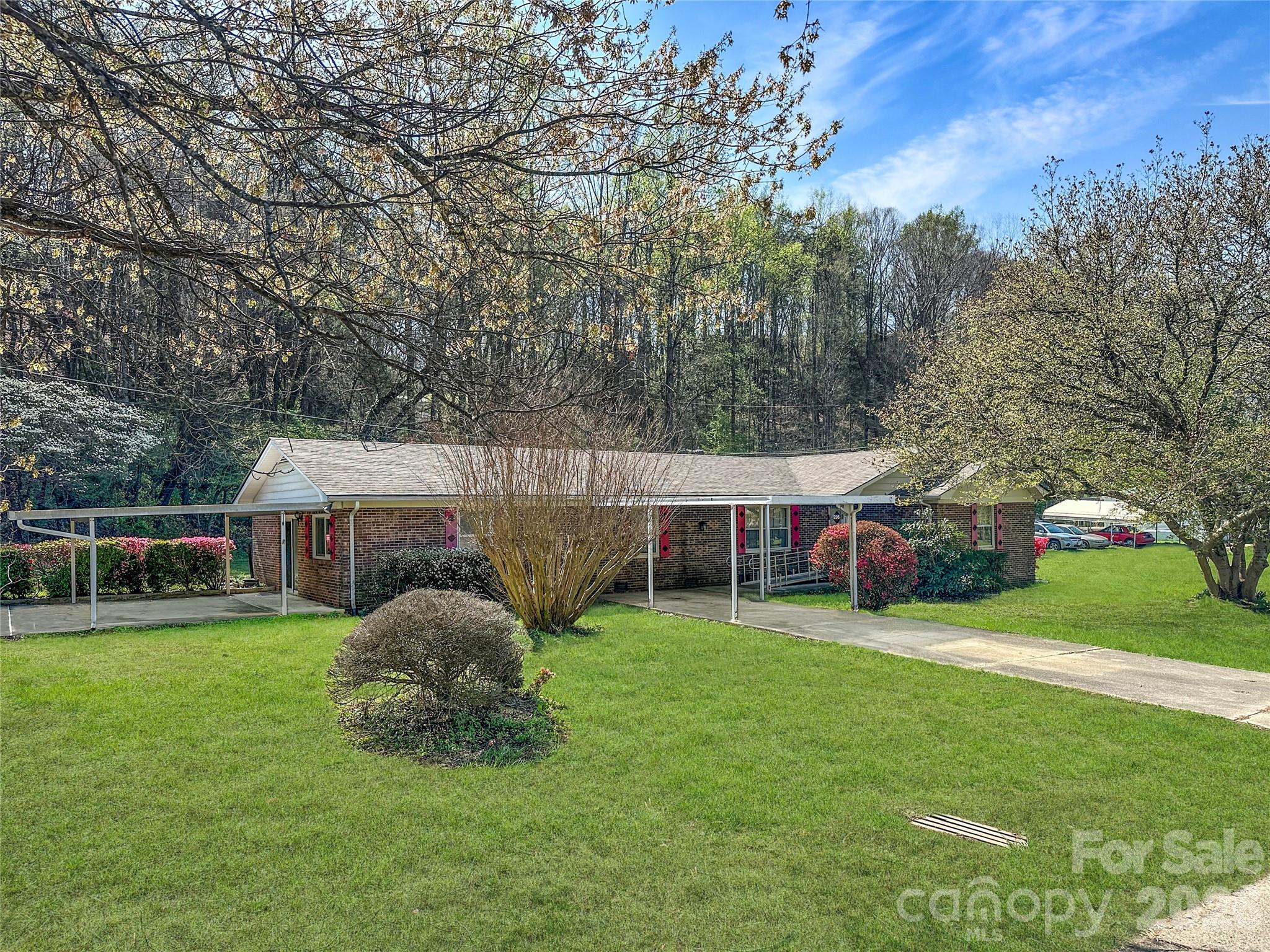 a view of a house with a big yard and large trees