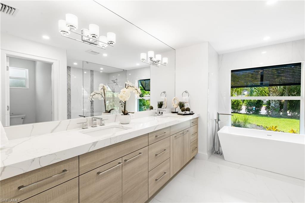 2001 Alamanda Drive Naples, FL 34102 - Photo 14 of 32 a bathroom with a large tub sink and large mirror