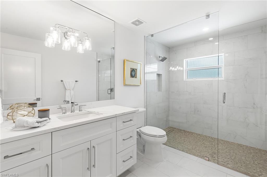 2001 Alamanda Drive Naples, FL 34102 - Photo 16 of 32 a bathroom with a double vanity sink mirror and toilet