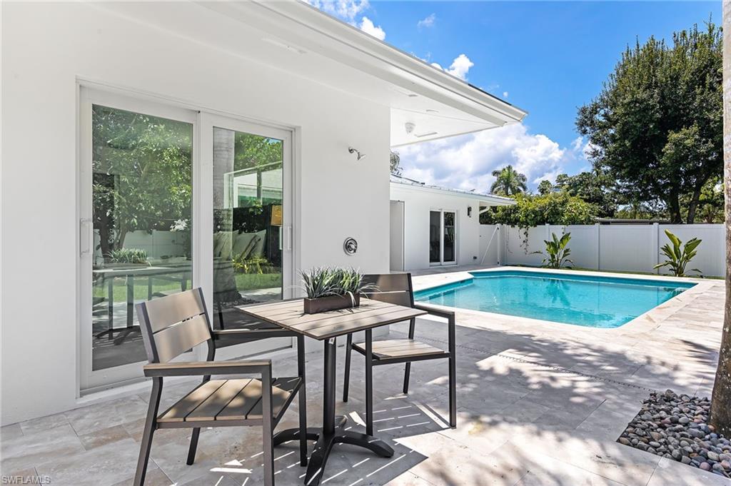 2001 Alamanda Drive Naples, FL 34102 - Photo 21 of 32 a view of patio with table and chairs next to a yard