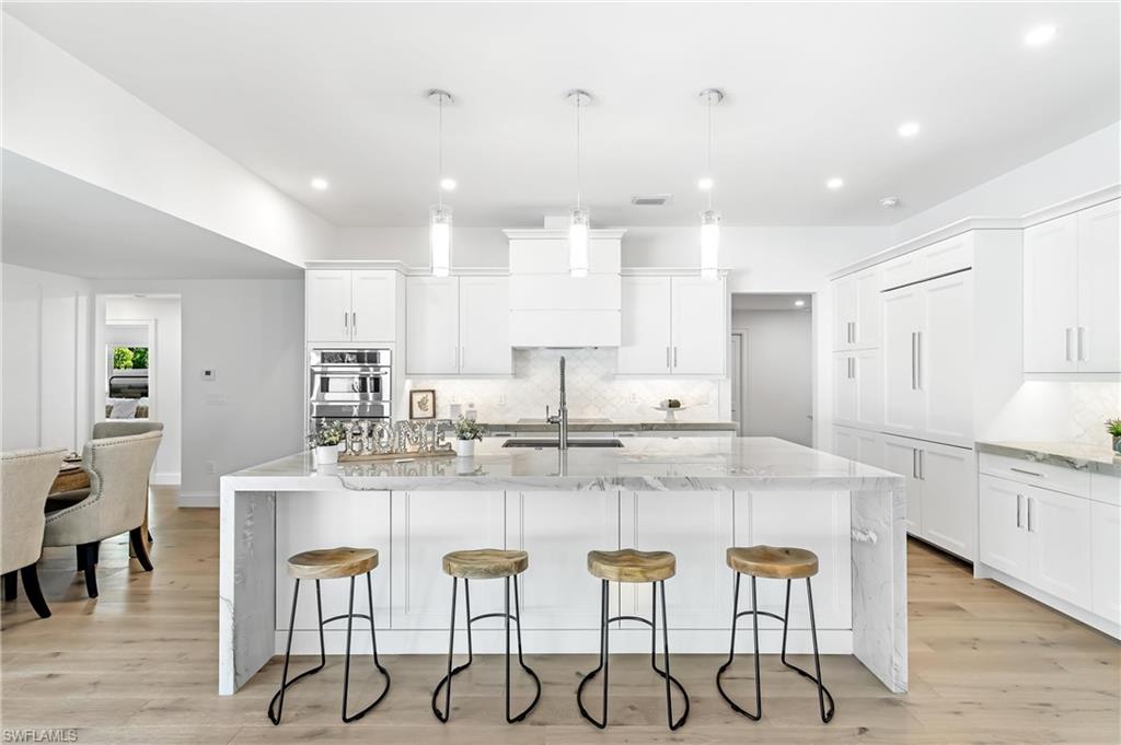 2001 Alamanda Drive Naples, FL 34102 - Photo 5 of 32 a kitchen with kitchen island granite countertop a table and chairs in it