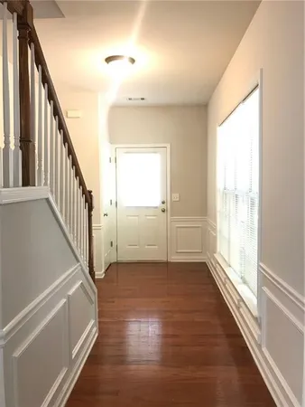 a view of a hallway with wooden floor and staircase