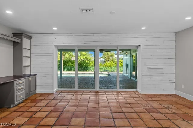 a view of a hallway with wooden floor and a bathroom