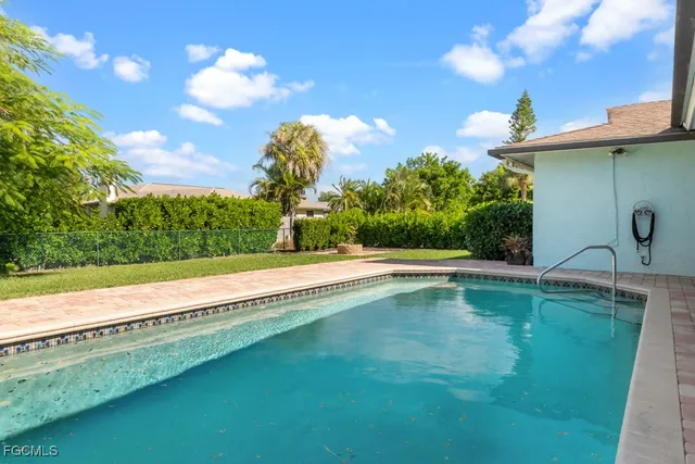a view of yellow house with a swimming pool