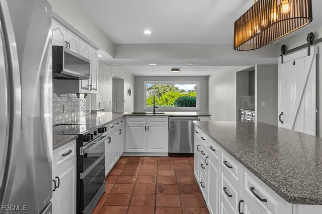 a kitchen with stainless steel appliances granite countertop a sink and dishwasher a stove with wooden floor
