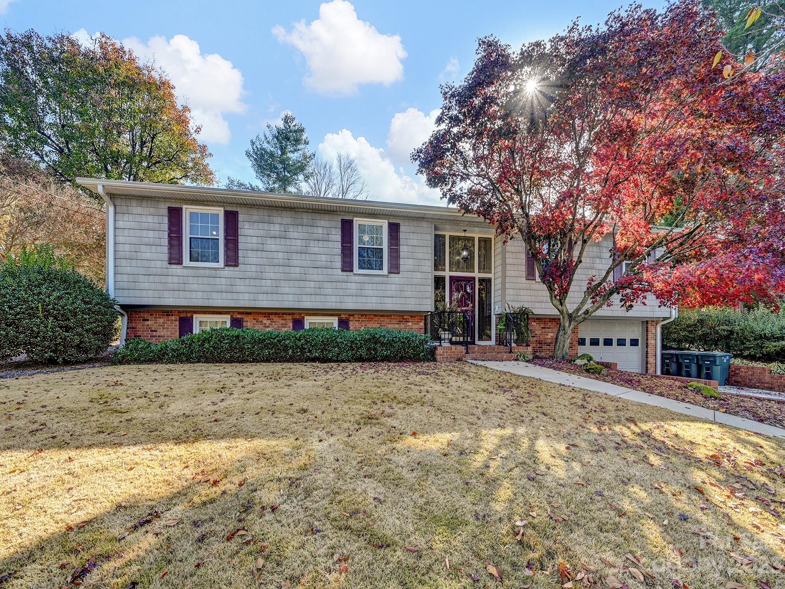 a front view of a house with a yard and trees