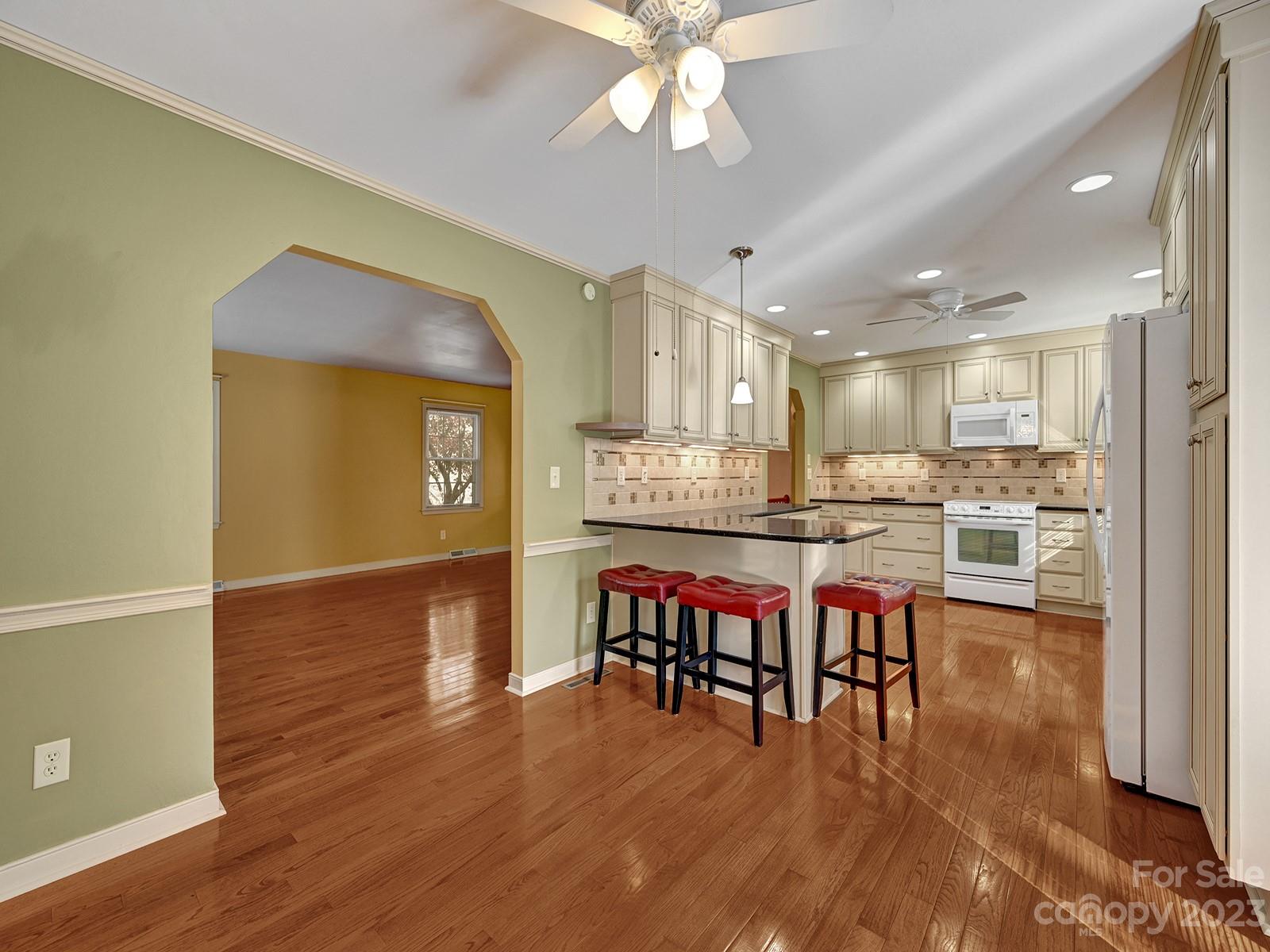 4130 Witherow Road Winston-Salem, NC 27106 - Photo 11 of 39 a dining hall with stainless steel appliances kitchen island a table chairs and a refrigerator