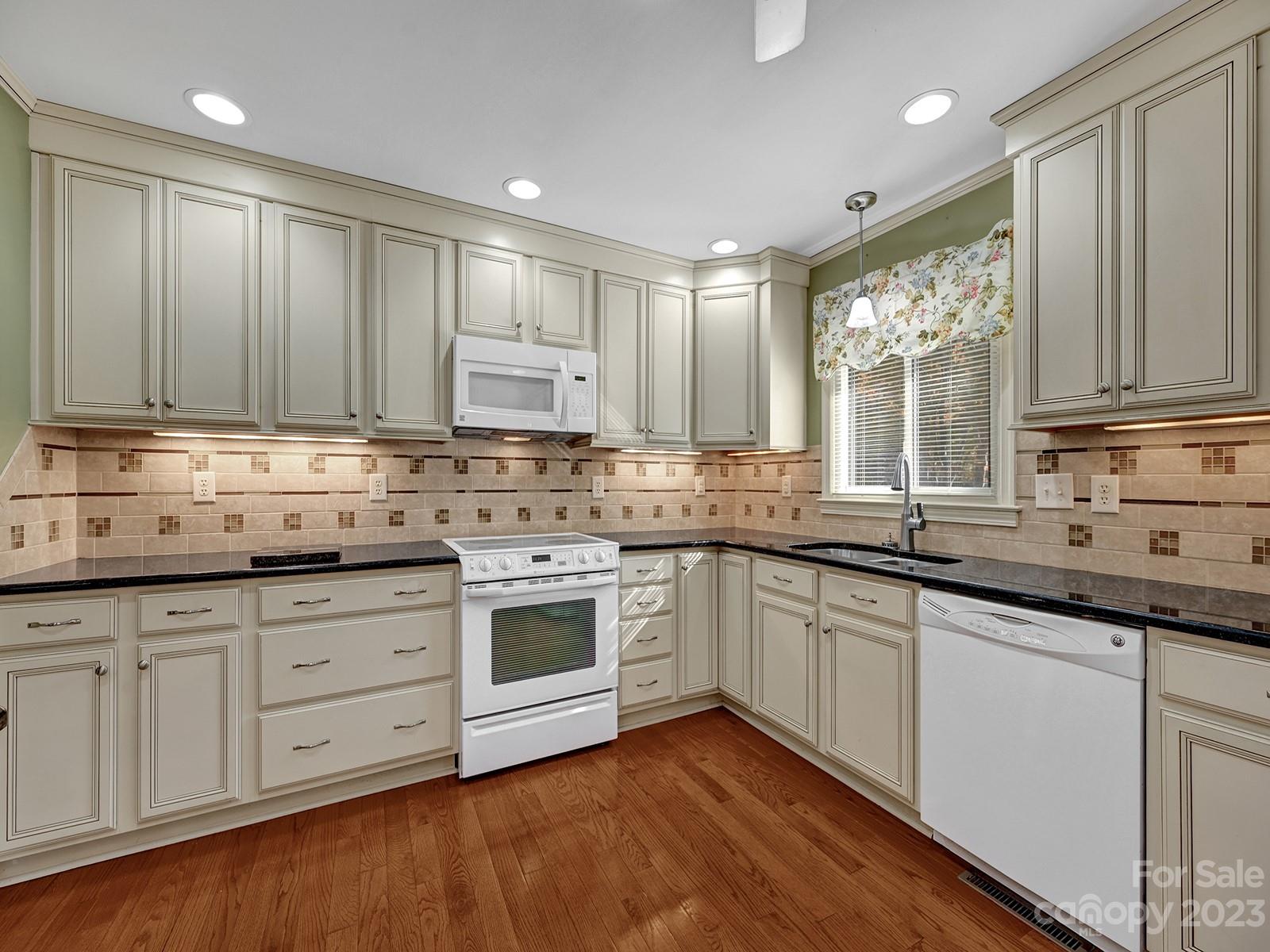 4130 Witherow Road Winston-Salem, NC 27106 - Photo 13 of 39 a kitchen with stainless steel appliances granite countertop a stove a sink and white cabinets
