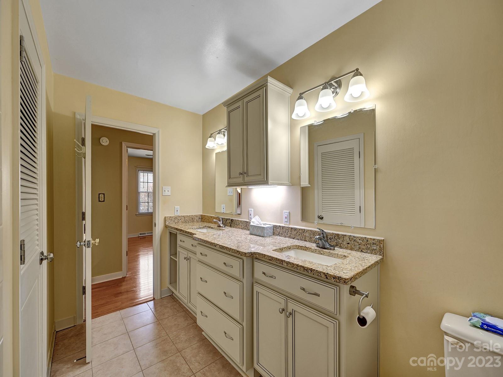 4130 Witherow Road Winston-Salem, NC 27106 - Photo 18 of 39 a spacious bathroom with a granite countertop sink a mirror and a shower