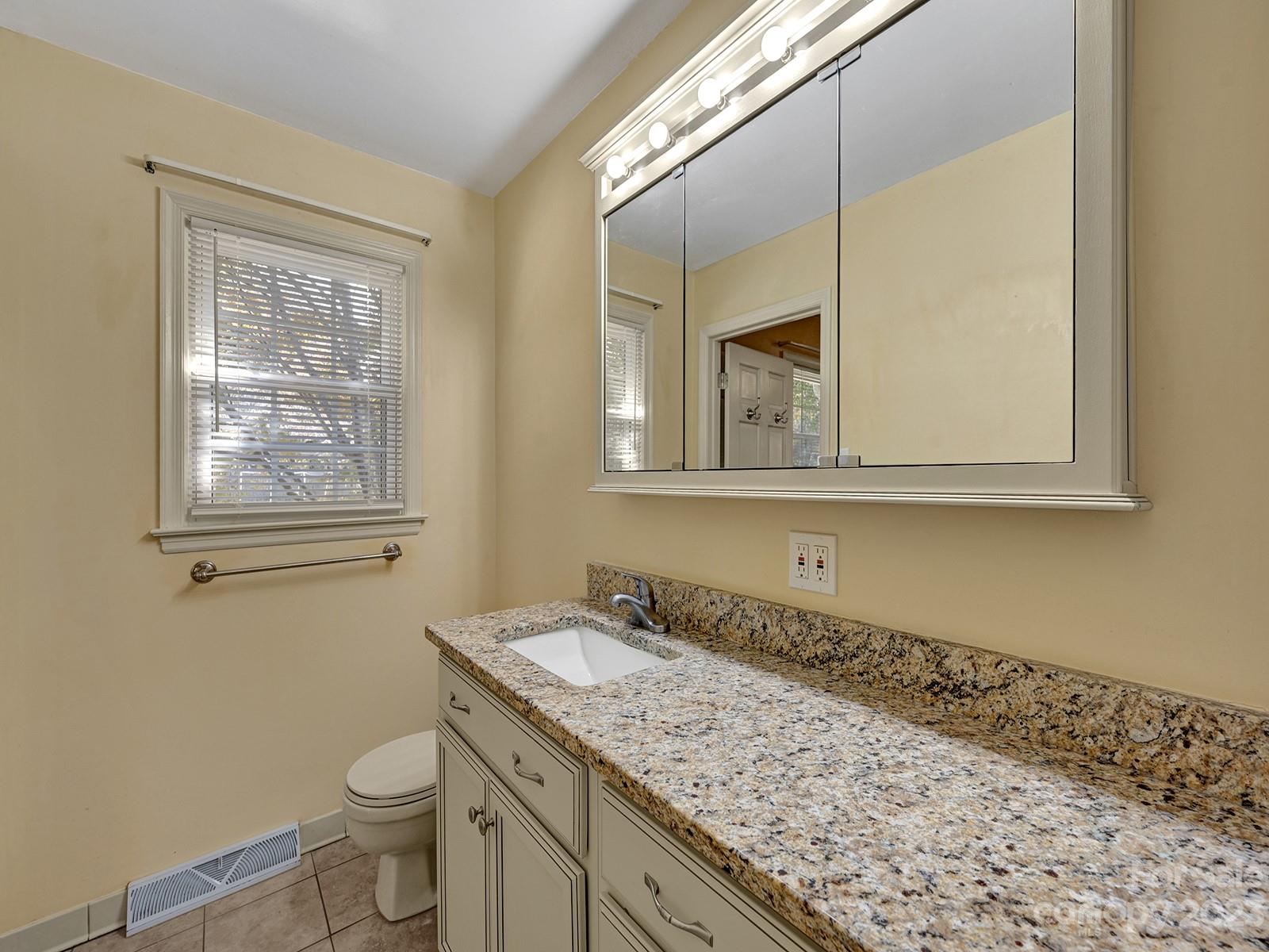 4130 Witherow Road Winston-Salem, NC 27106 - Photo 26 of 39 a bathroom with a granite countertop sink mirror vanity and toilet