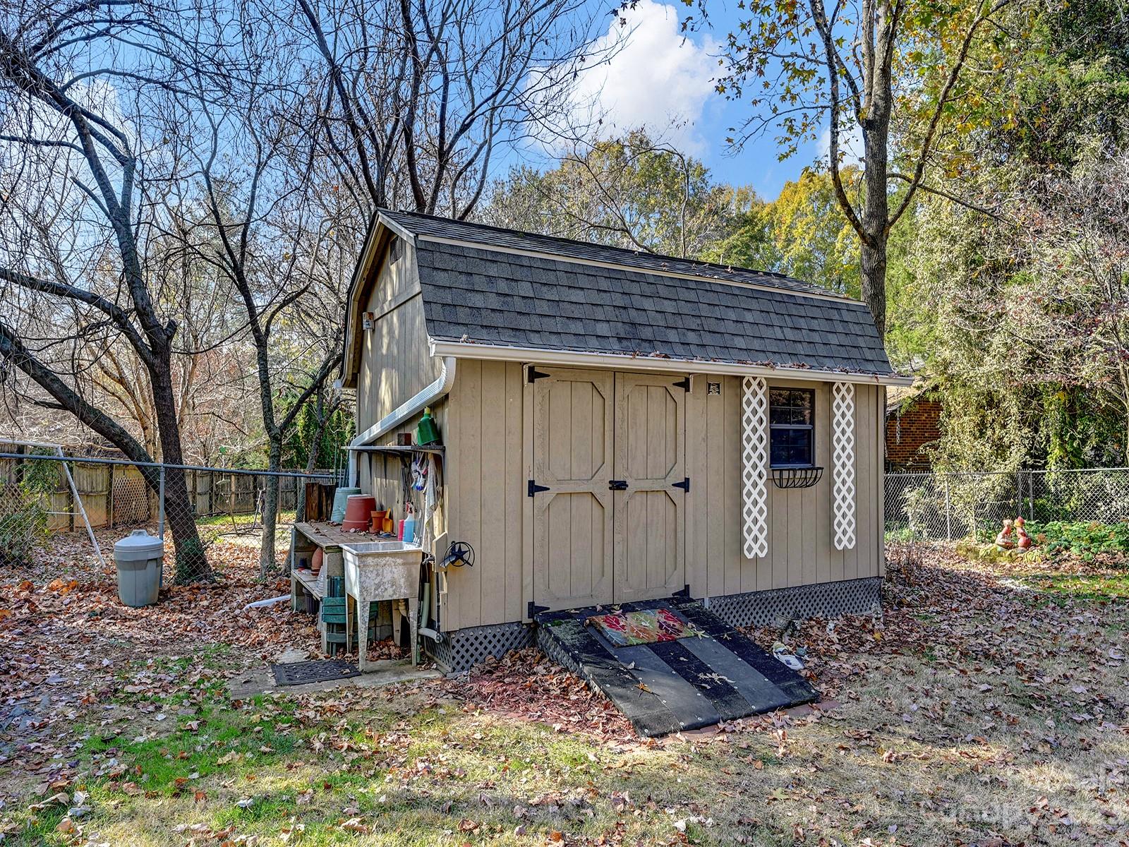 4130 Witherow Road Winston-Salem, NC 27106 - Photo 37 of 39 a view of a house with a yard chairs and table under an umbrella