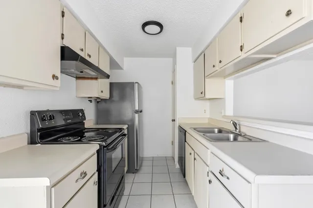 a kitchen that has a sink and a stove