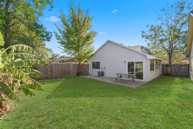 a backyard of a house with table and chairs