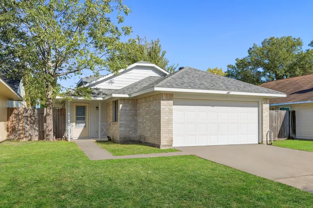 a front view of a house with a garden and yard