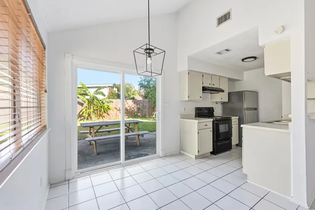 a kitchen with a refrigerator a stove top oven a sink and a window