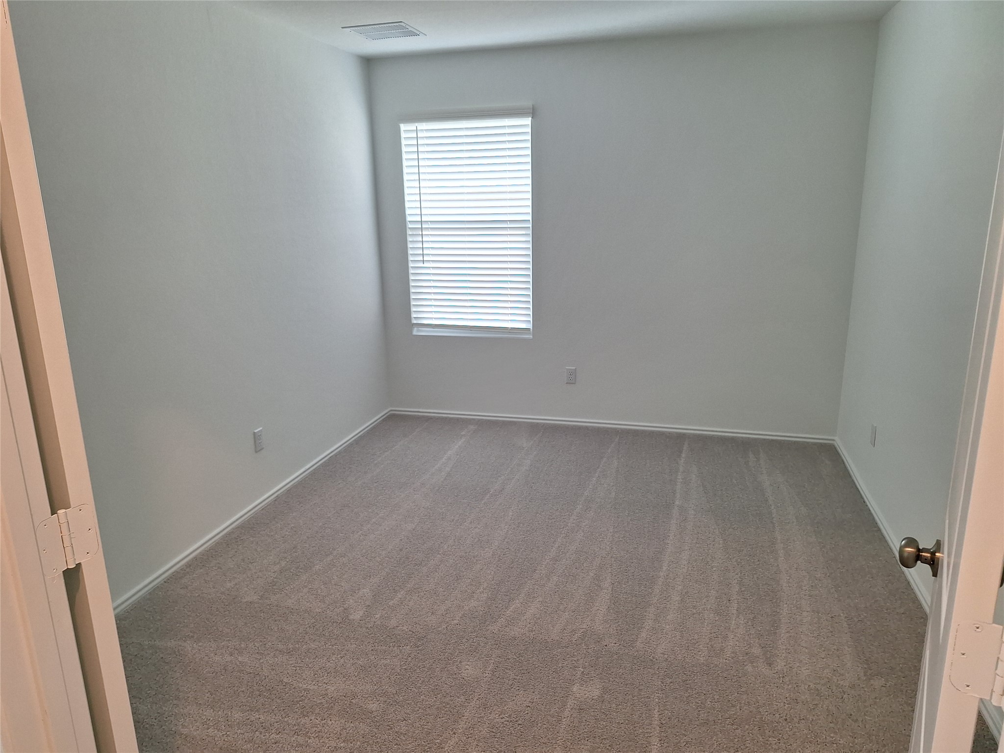 18001 Prairie Falcon Way Pflugerville, TX 78660 - Photo 19 of 38 Room featuring light gray carpet, white walls, white trim, and a window with blinds